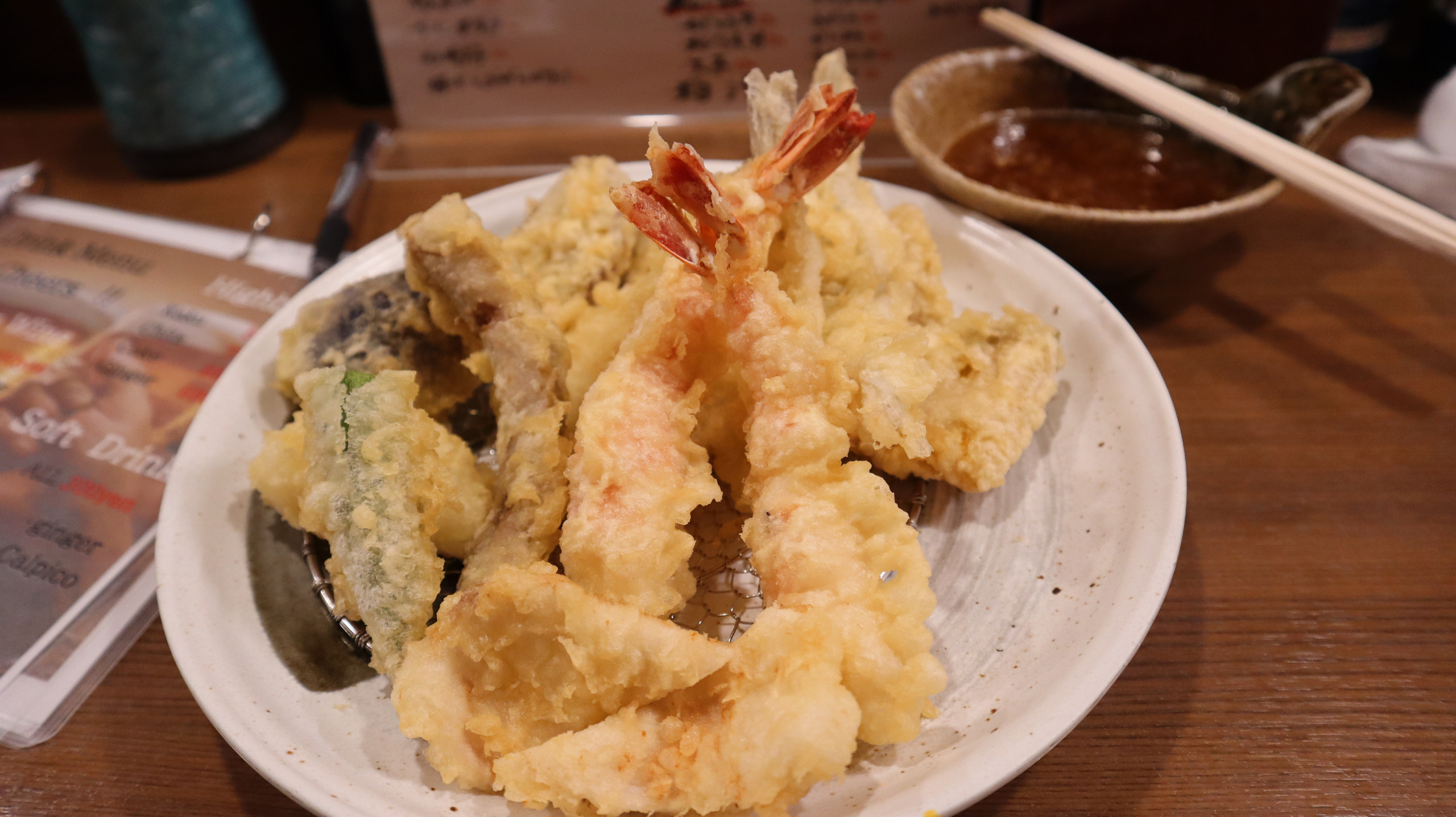 难波まきの的一盘天妇罗,虾尾朝上,虾与蔬菜铺在金属网上