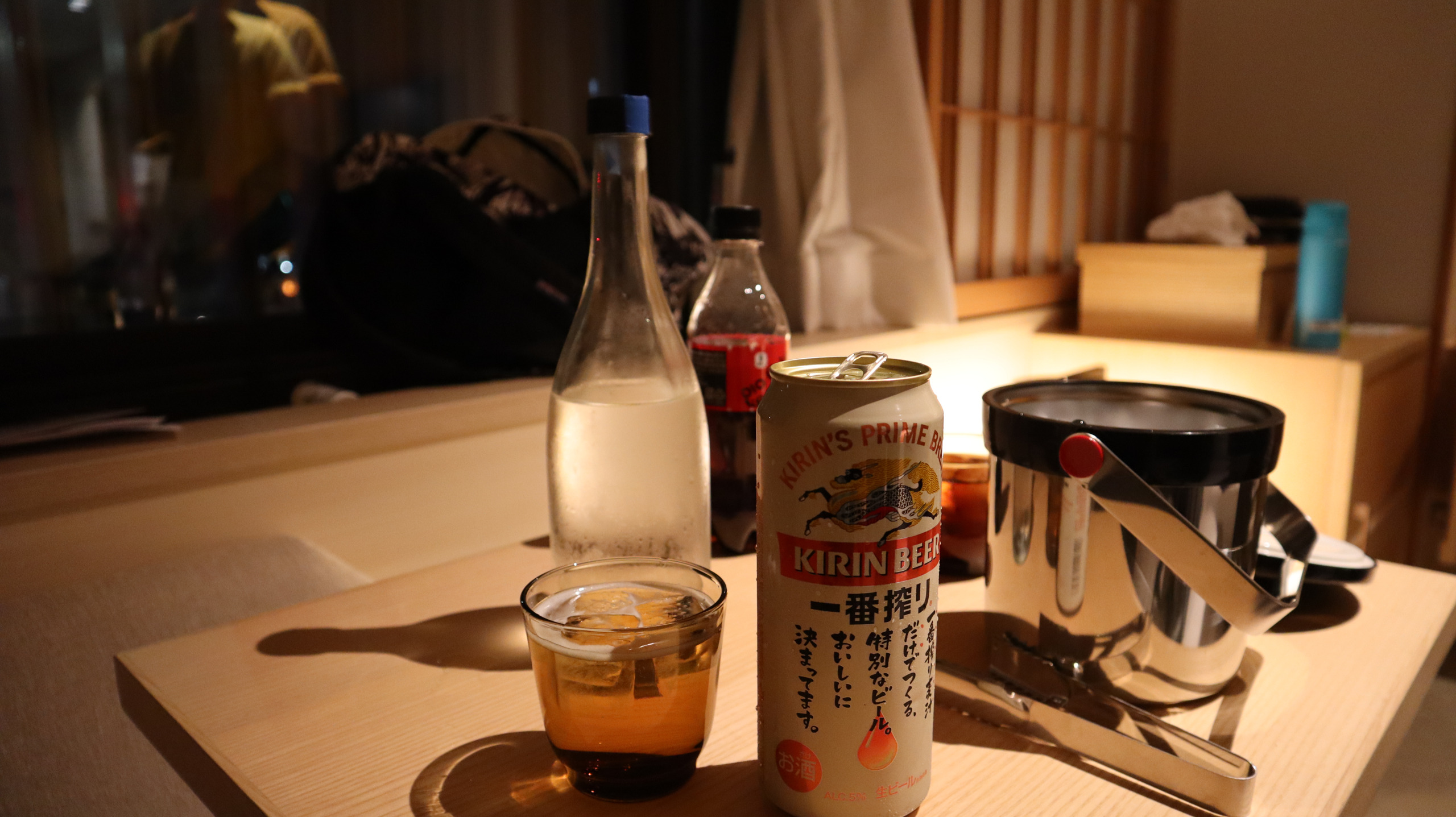 酒店客房桌上的一番榨、水瓶与冰桶，行李放在窗边