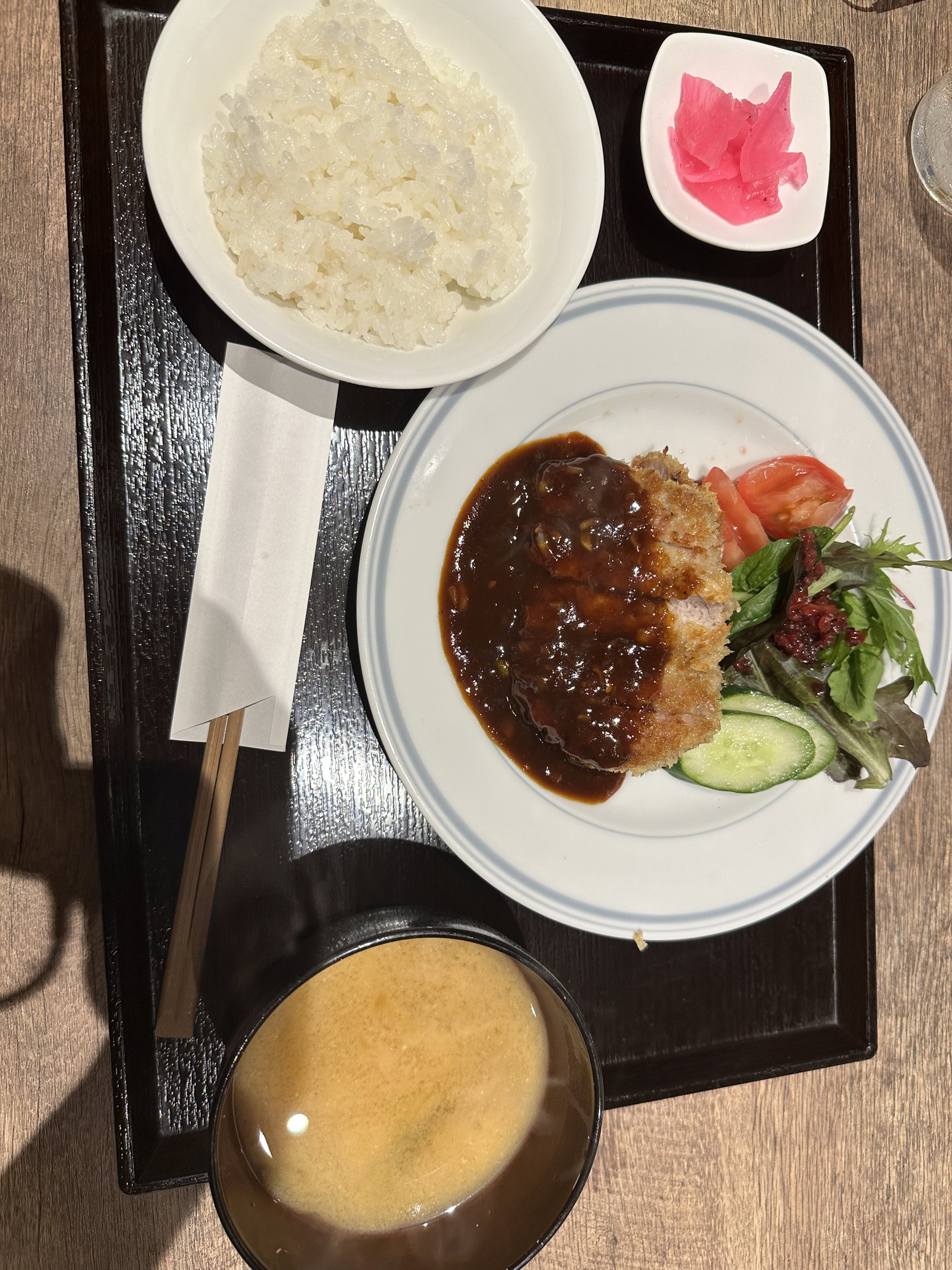 大阪的午餐托盘:浇着深色酱汁的炸物、蔬菜、白饭、汤与腌菜