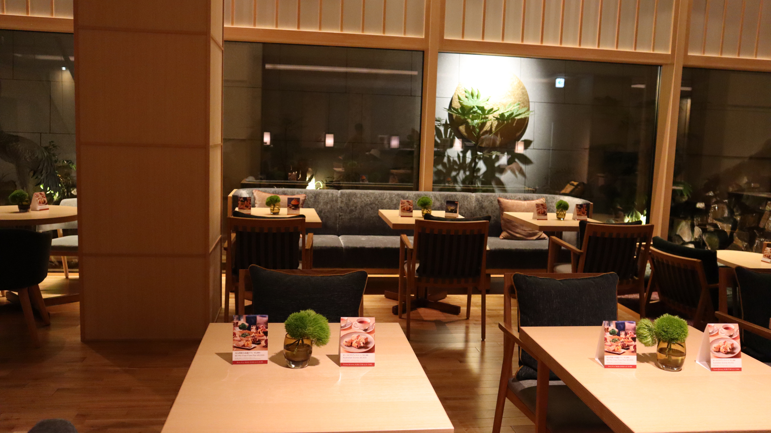 酒店餐厅的木色桌椅、桌面绿植与暖光