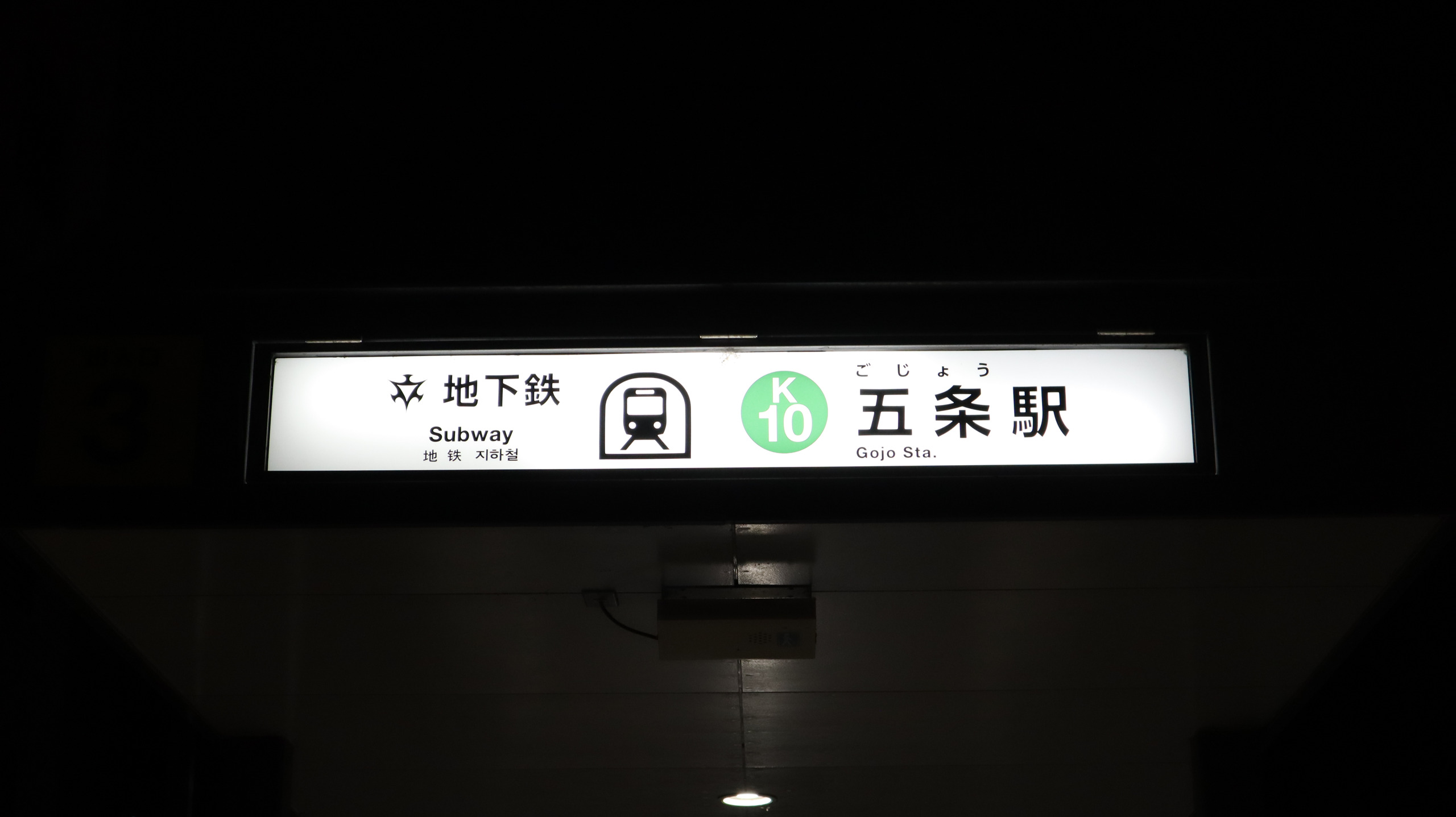 夜色中的京都地铁五条站入口灯箱，标着 K10