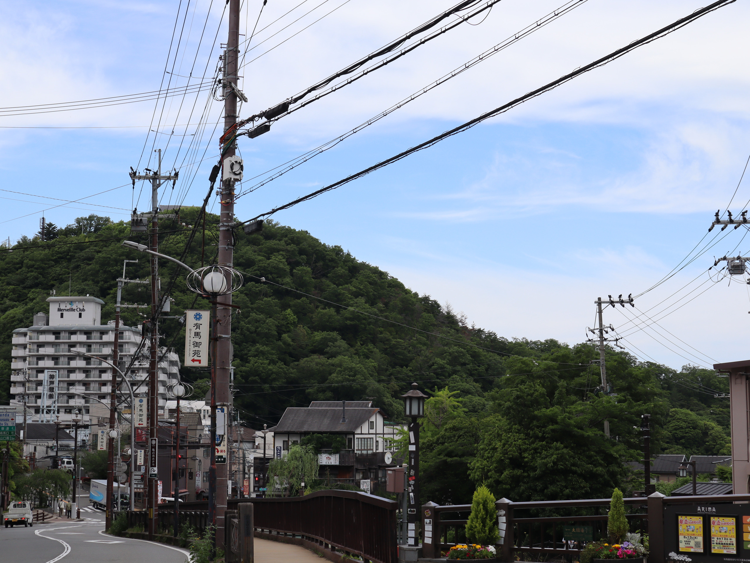 有马温泉街的电线杆、山坡与楼房,头顶是蓝天薄云