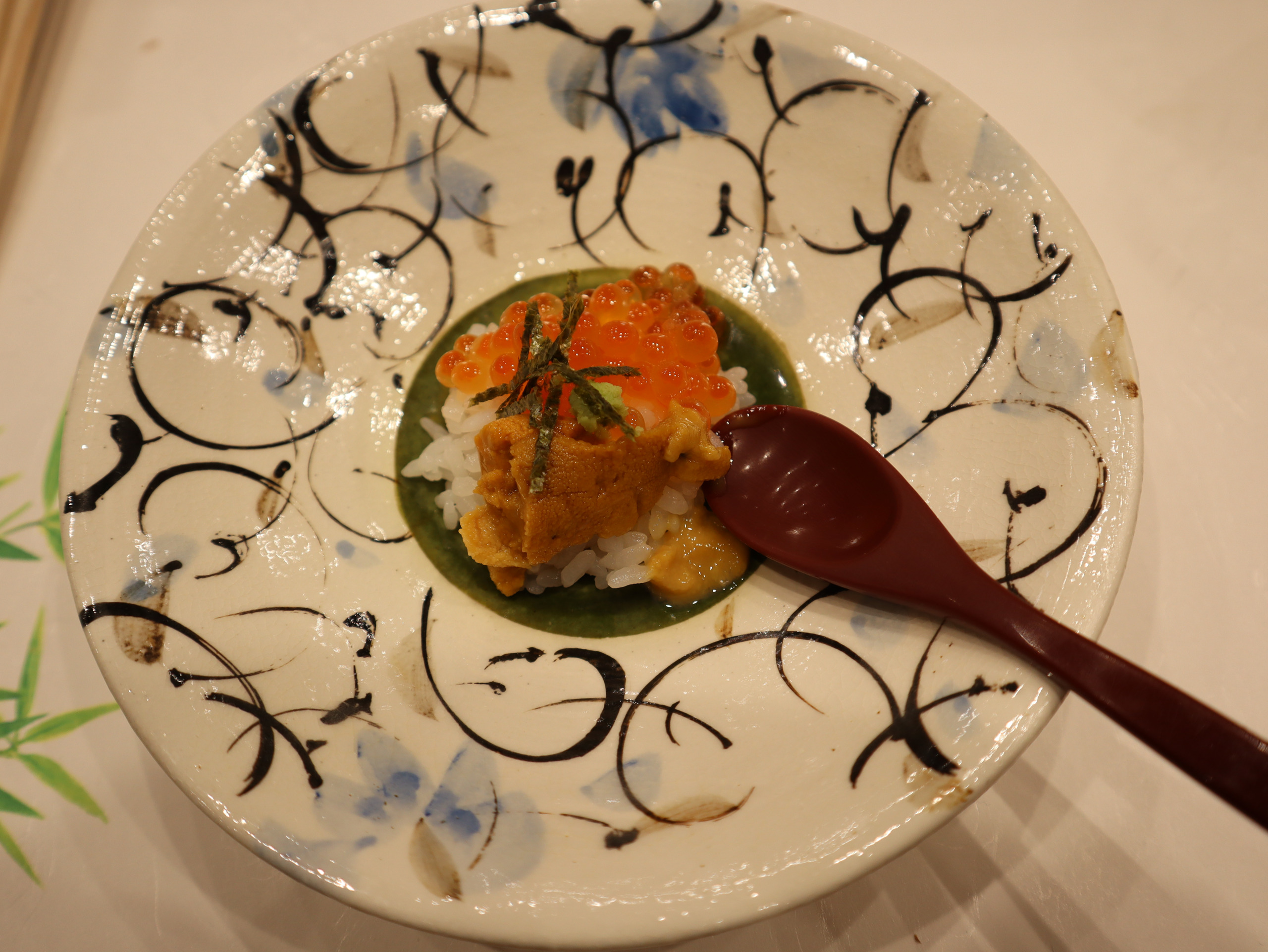 花纹浅盘中的午餐菜品，旁边斜放着木勺
