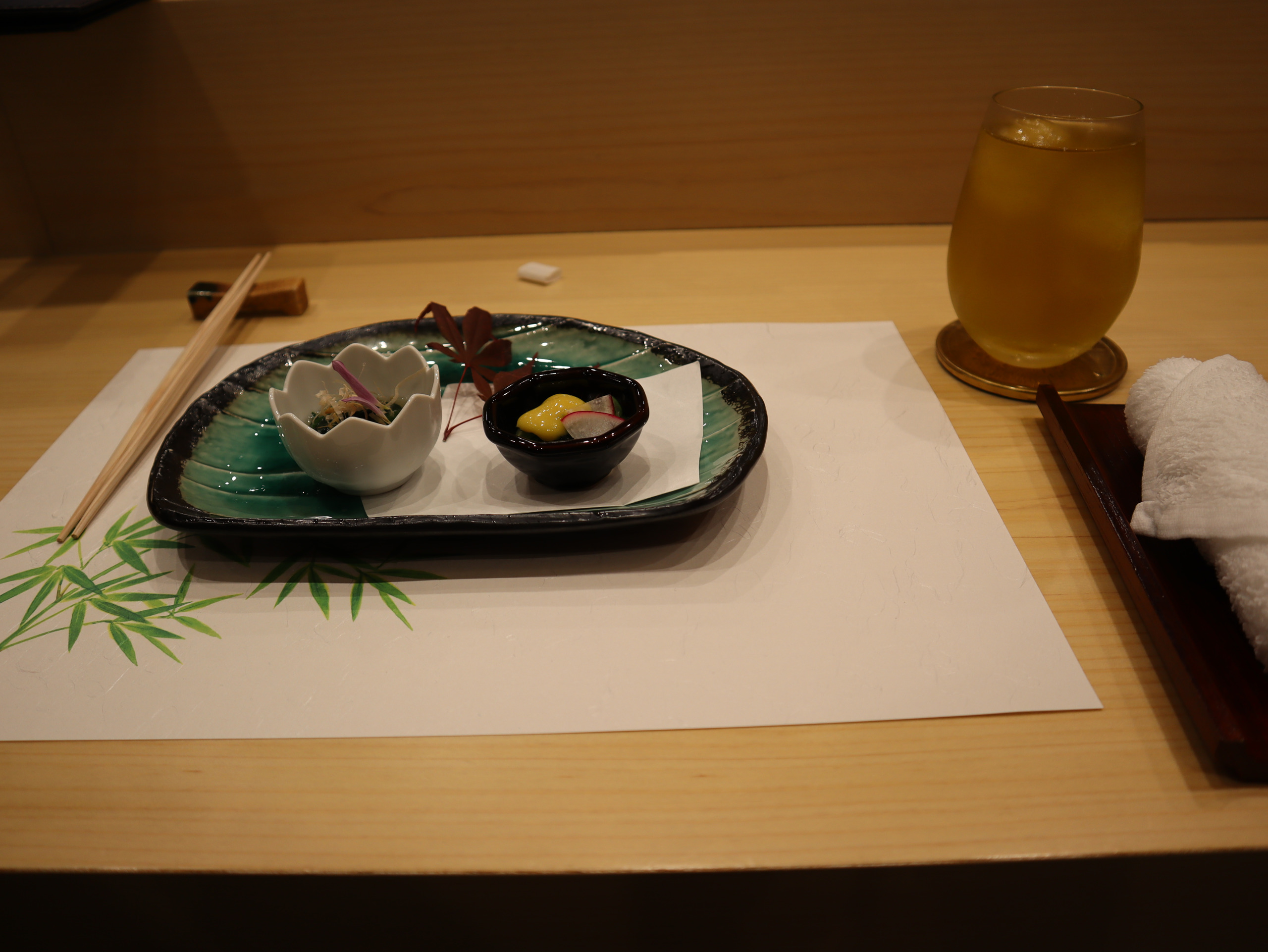 午饭开始时的小菜、绿竹餐垫与一杯金黄色饮料