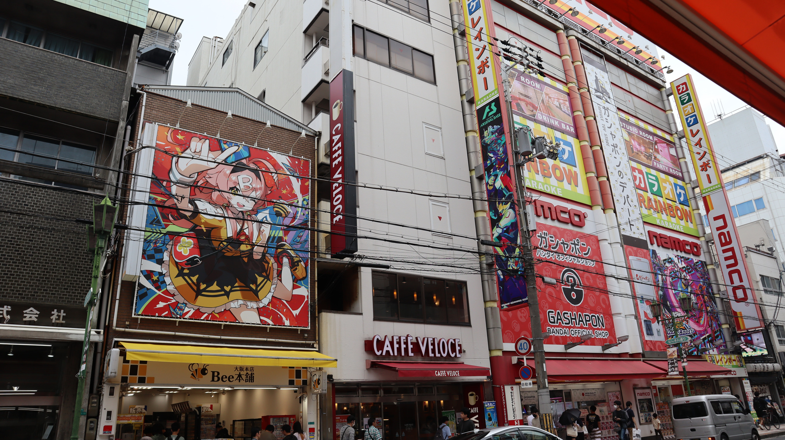 难波中街头的 namco 大楼,游戏、扭蛋招牌与人物画铺满外墙