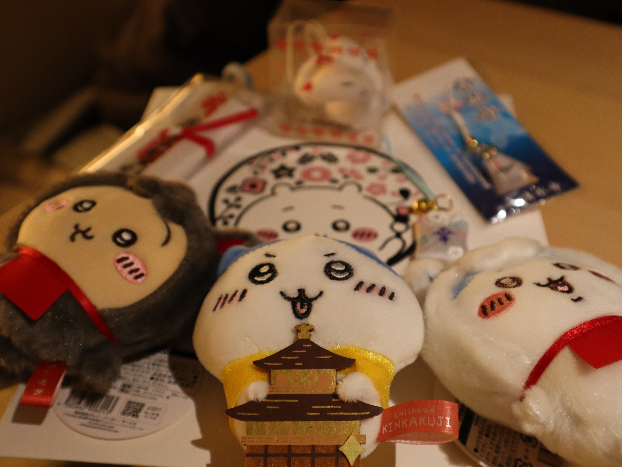 酒店桌上摆开的京都购物纪念品，中间玩偶带有金阁图案与 KINKAKUJI 标签