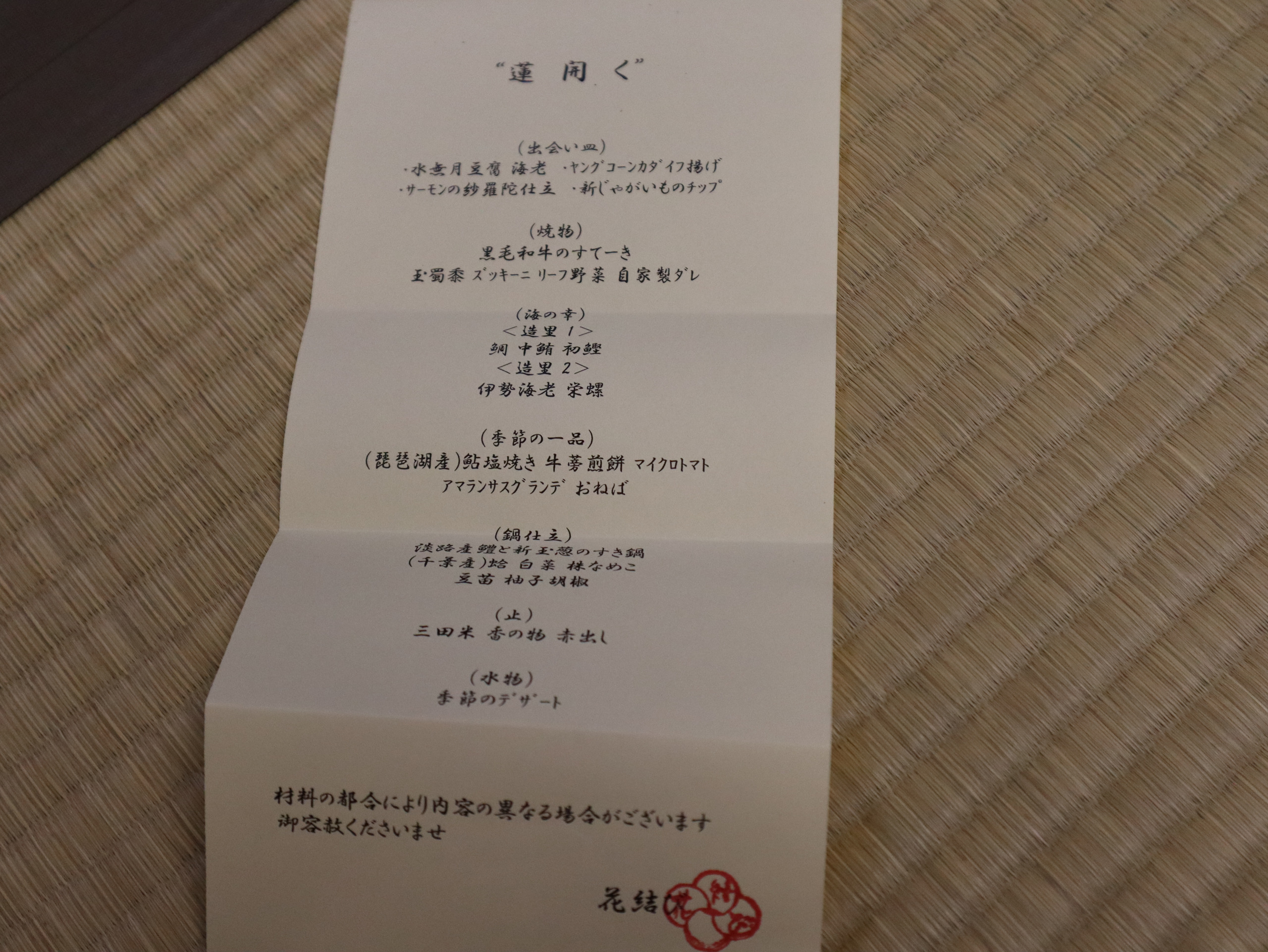 榻榻米上的晚餐菜单，题头为「蓮開く」，底部可见「花結」字样
